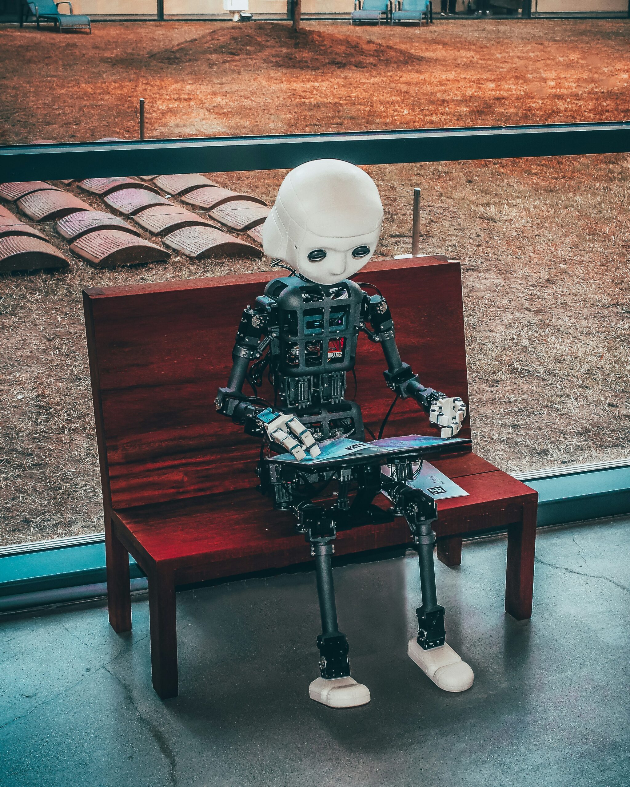 Fake It Till You Bank It: How to Use AI Clones to Run 7 ‘Agencies’ from a Beach Bar black and white robot toy on red wooden table