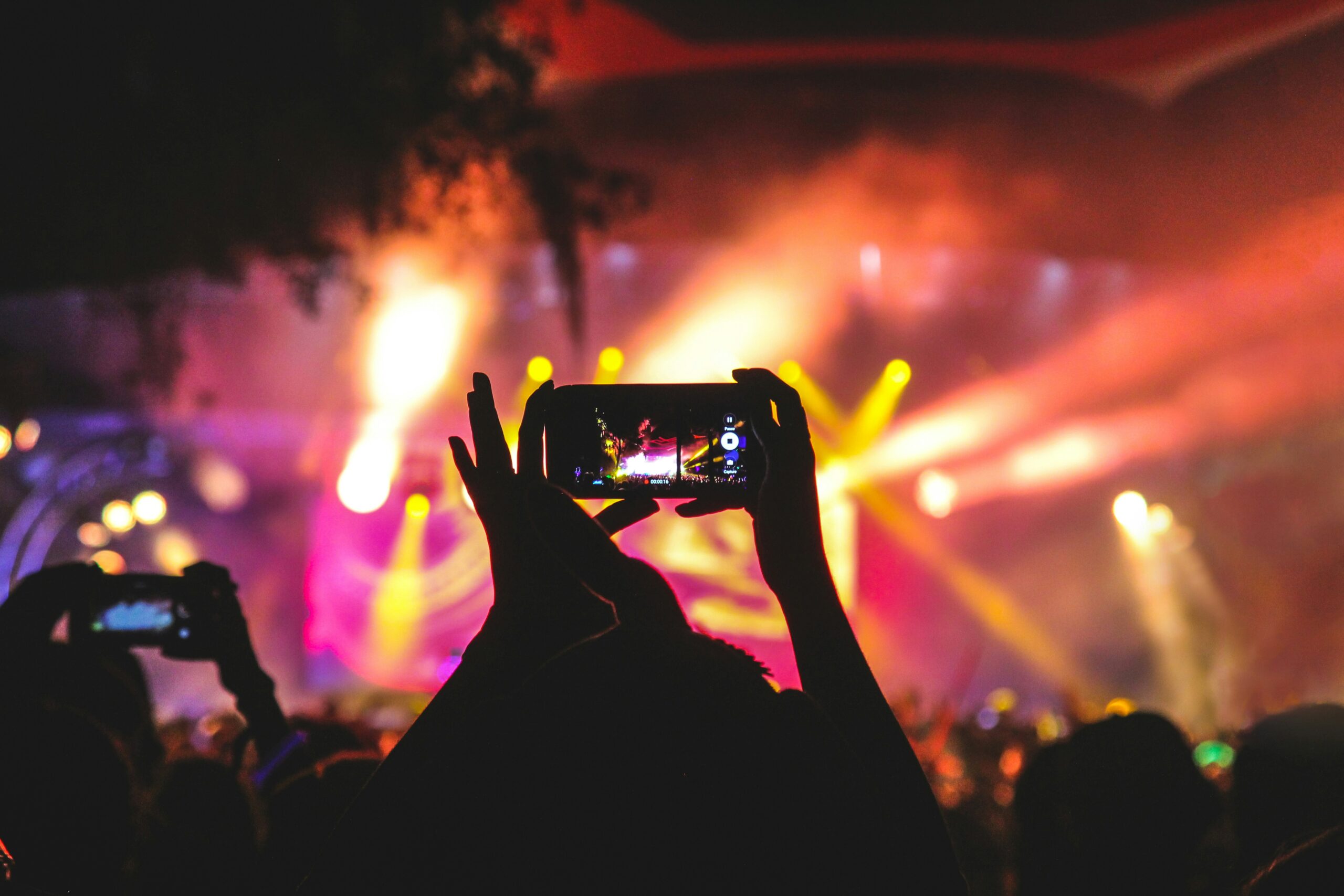 The Ultimate Dance Challenge Retirement Plan: Teaching Boomers to Floss at $99/Video person holding smartphone taking video of a concert near stage with lights during nighttime